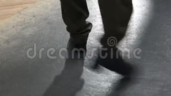 单女踢踏舞者穿着裤子在有反光地板的工作室里展示各种台阶视频的预览图