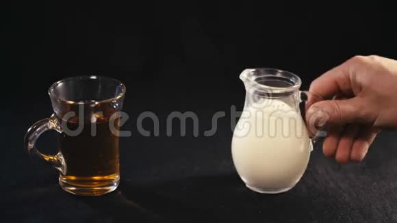 在透明杯中倒入茶叶的牛奶视频的预览图