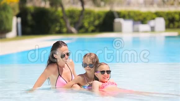 妈妈和两个孩子在豪华游泳池里享受暑假视频的预览图