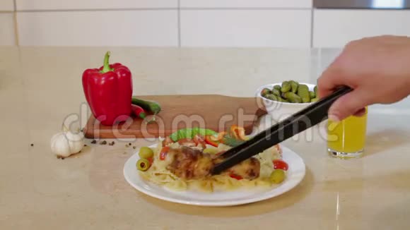 男人把热鸡腿放在盘子里和意大利面视频的预览图
