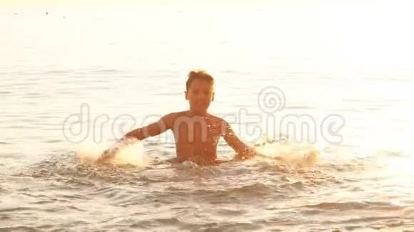 日落时分在海上玩的男孩慢动作视频的预览图