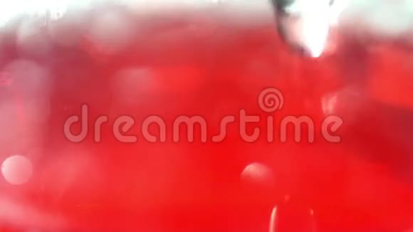 一个红色碳酸饮料倒入一个透明的高玻璃视频的预览图