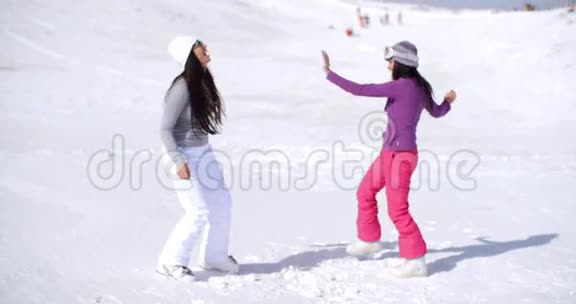 两个年轻女子在冬天的雪中嬉戏视频的预览图