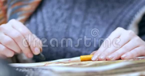 艺术家的年轻双手女艺术家用石墨铅笔绘制画布坐在桌子上画画布视频的预览图