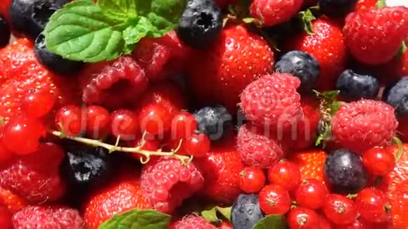 红色成熟的花园草莓和蓝莓浆果在白色桌子上旋转背景美丽视频的预览图