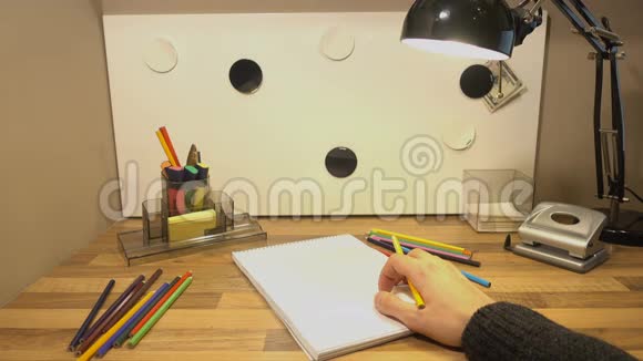 彩色铅笔在桌子上的手拿着铅笔想在上面画画视频的预览图