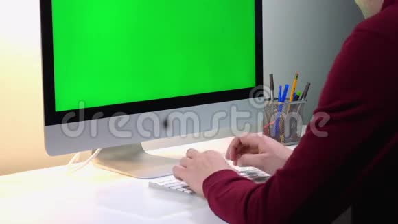 设计师在绿色背景的电脑上工作视频的预览图