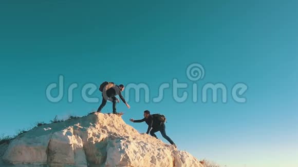 攀爬帮助队友攀爬拿着背包的人伸出一只帮助他的朋友的手帮助朋友视频的预览图