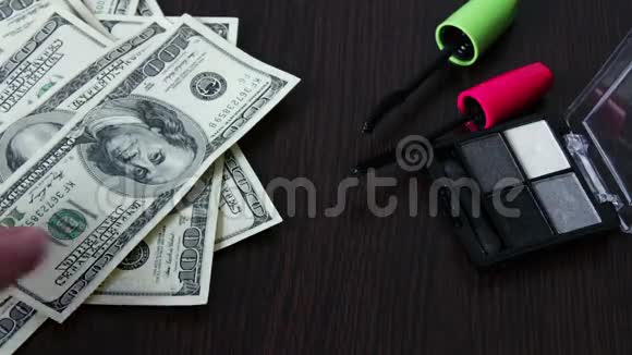 几百美元的钞票和化妆品在桌子上视频的预览图