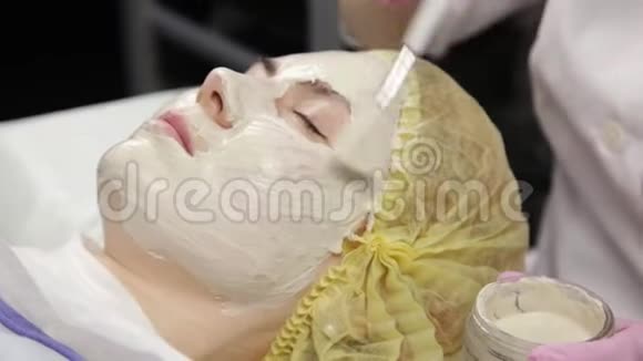 美容师把面膜敷在问题皮肤上清洗皮肤的年轻妇女视频的预览图