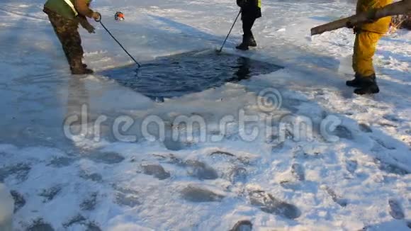 渔民在湖上切冰为鱼提供氧气在湖上切冰为鱼制造通风口视频的预览图