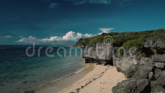从巴厘岛的盖格海滩俯瞰干净幽静的白色海滩和悬崖视频的预览图