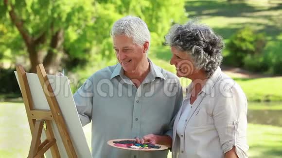 微笑成熟男人在妻子面前画画视频的预览图