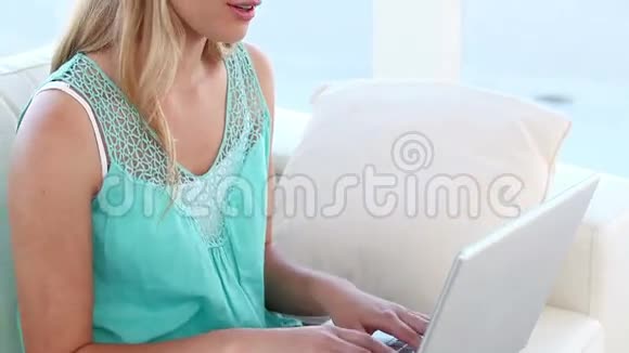金发女人在笔记本电脑前听音乐视频的预览图