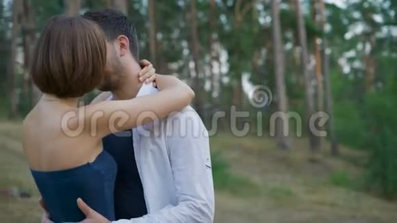 浪漫的一对年轻人正在夏天的森林里拥抱一片空地视频的预览图