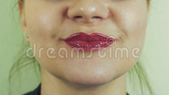 在镜头前一个嘴唇上涂着红色发油的女人在唱歌嘴巴表达视频的预览图