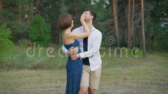 浪漫的一对年轻人正在夏天的森林里拥抱一片空地视频的预览图