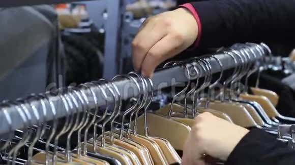 女性双手触摸一个衣架衣服在精品店视频的预览图