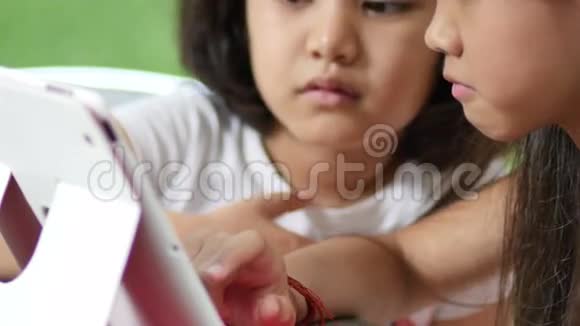 在公园看平板电脑的亚洲小孩视频的预览图