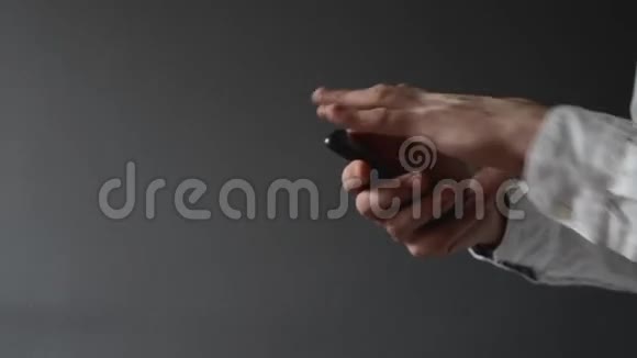 使用智能手机的商人双手滚动并键入屏幕视频的预览图