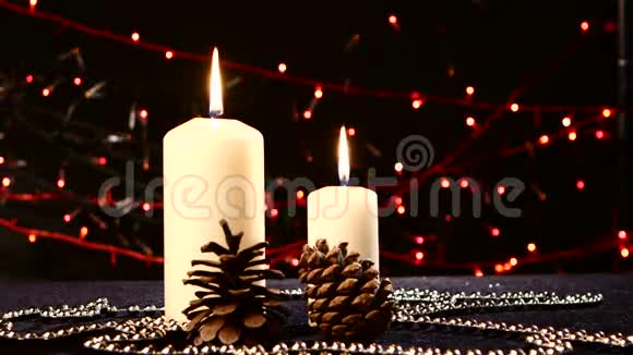 两支白色的大蜡烛和松果作为圣诞礼物视频的预览图