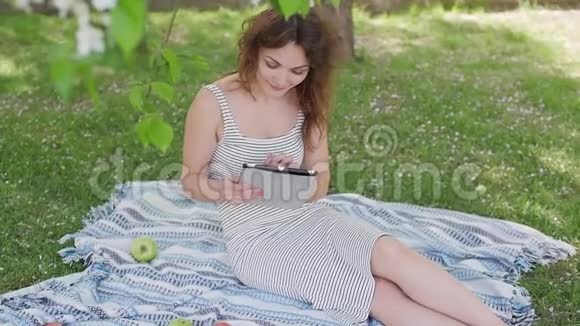 公园里有平板电脑的女孩在互联网上交流视频的预览图