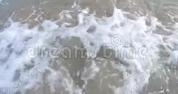 海水的波浪和沙滩的波浪轻轻地冲刷到海滩上视频的预览图