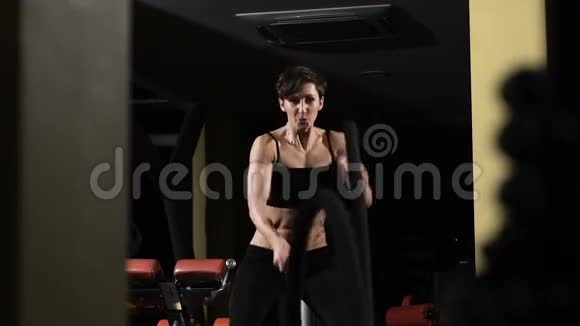 交叉配合肌肉发达的女人用绳子在交叉健身馆锻炼视频的预览图