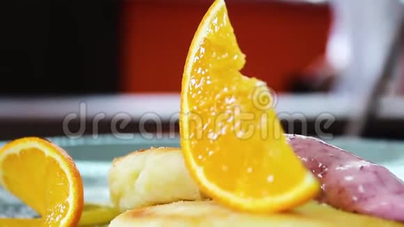 准备好的芝士蛋糕盘子上有两个酱汁和一片橘子视频的预览图