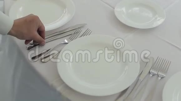 侍者整齐地把餐具放在一张桌子上桌上有一张白色的桌布用来宴会视频的预览图