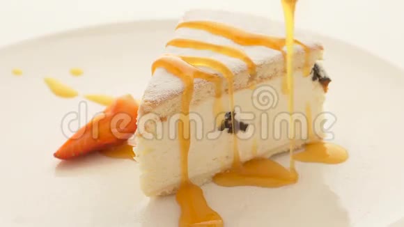 芝士蛋糕切片在白色桌子上放酱汁视频的预览图