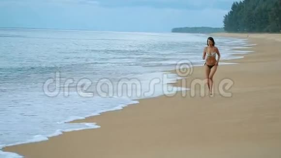 夏天在异国海滩上奔跑的快乐女人视频的预览图