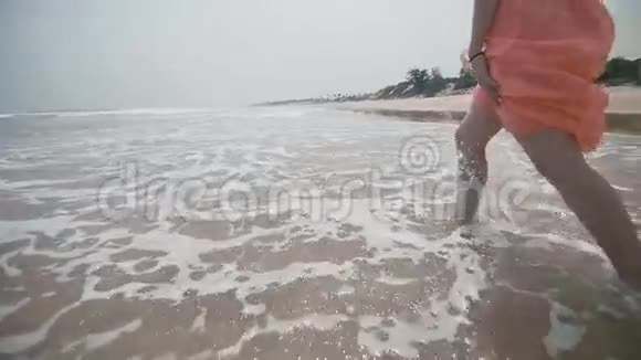 可爱可爱脆弱的女孩在海滩上跑来跑去视频的预览图