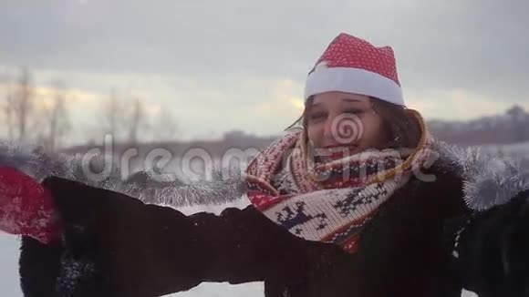 快乐的年轻美丽的女人戴着圣诞帽在冬天的户外玩得很开心雪地的自然慢动作1920x1080视频的预览图