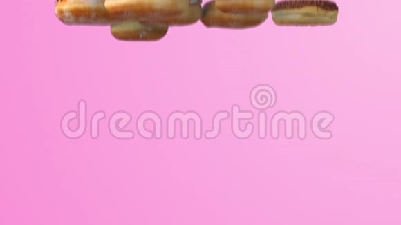 在粉色背景上落下不同的甜甜圈视频的预览图