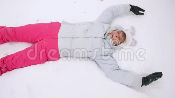 快乐成熟的女人躺在雪堆里慢慢地享受着降雪1920x1080视频的预览图