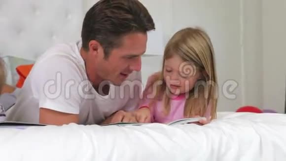 家庭躺在床上一起读书视频的预览图