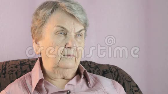 坐在室内的老妇人捂着她的手视频的预览图