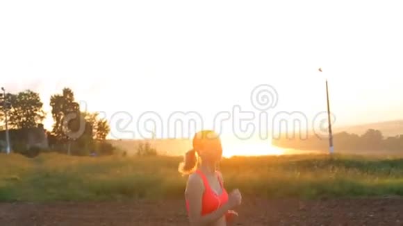 做女人跑步者在阳光明媚的光线下慢跑视频的预览图