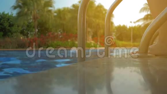 一个漂亮的女孩走进游泳池夏日的阳光视频的预览图