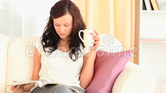 女人一边喝茶一边看杂志视频的预览图