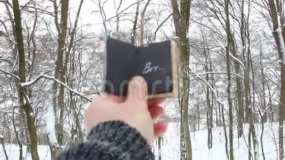 弗罗斯特的主意手拿着一本铭文的书描绘了森林的背景视频的预览图
