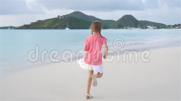可爱的小女孩在加勒比海岛的海滩上玩得很开心慢动作视频的预览图