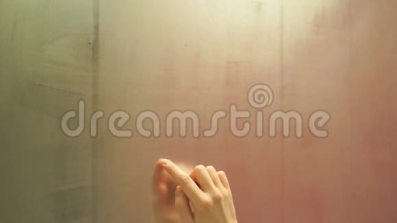 女孩用手指在雾蒙蒙的镜子上快速地画出一颗心视频的预览图