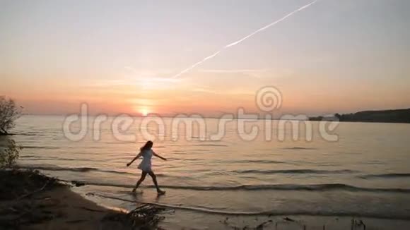 日落时分年轻女子在海上慢动作视频的预览图