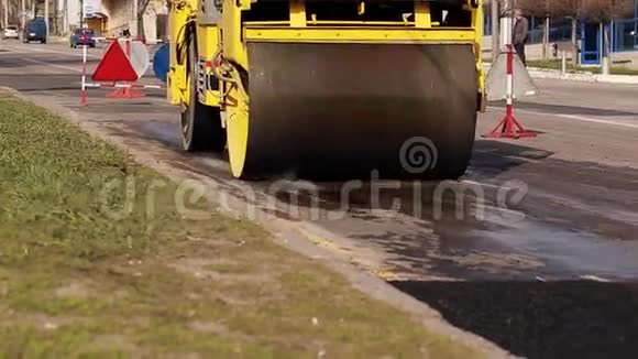 沥青压路机在最近修理的街道上工作视频的预览图