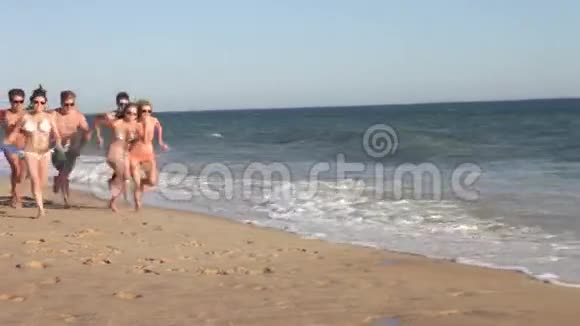 一群青少年沿着海滩奔跑视频的预览图