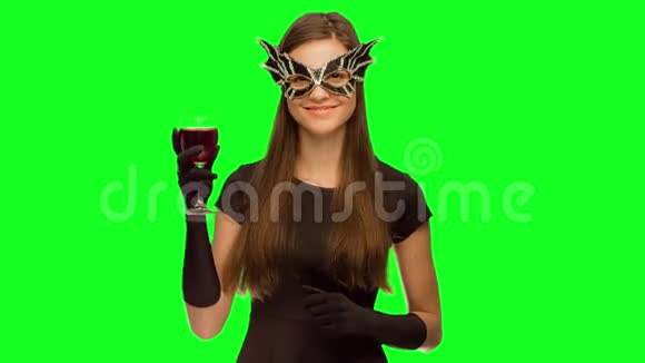 戴着面具和黑色连衣裙的女孩喝酒享受视频的预览图
