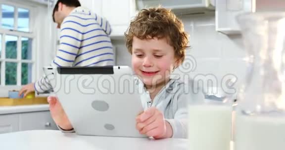 父亲用手机说话儿子用数码平板电脑视频的预览图
