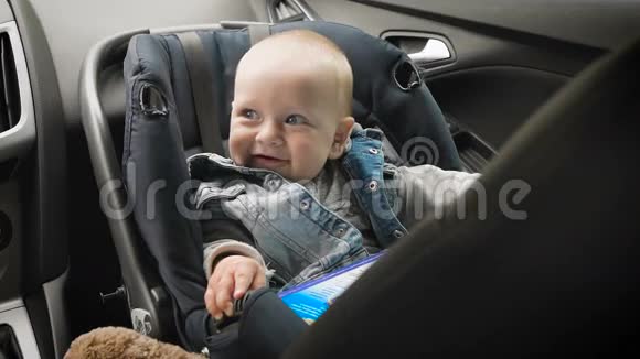 儿童的汽车安全小男孩坐在特别的汽车座位上视频的预览图